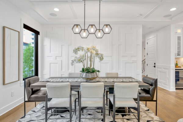 Spacious living room with a contemporary design, featuring a comfortable sofa, decorative throw pillows, and a modern coffee table. The open layout flows into the adjacent dining room, creating a seamless connection between the two spaces. Large windows bring in ample natural light, highlighting the neutral color palette and elegant decor. The dining area is furnished with a stylish table and chairs, creating a cohesive and inviting atmosphere throughout the room.