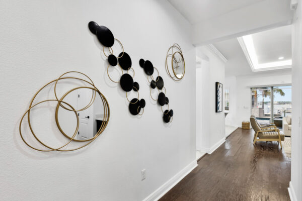 Interior hallway showcasing contemporary decor with neutral-toned walls and a sleek, modern design. The space is illuminated by soft lighting, and artwork or decorative pieces are displayed along the walls. The clean lines and minimalistic style emphasize the spaciousness of the hallway.