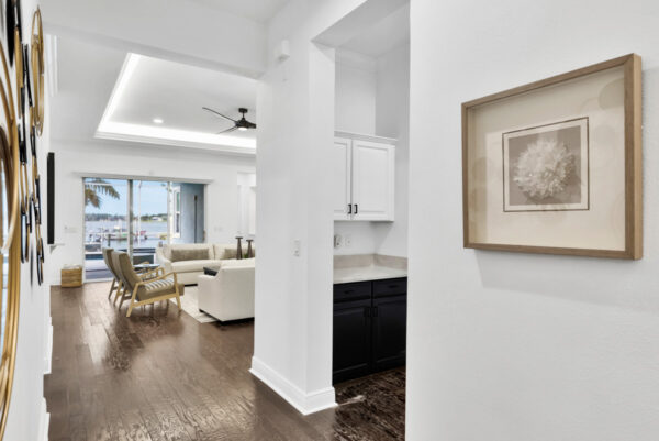Spacious living room with a contemporary design, featuring a comfortable sofa, decorative throw pillows, and a modern coffee table. The open layout flows into the adjacent dining room, creating a seamless connection between the two spaces. Large windows bring in ample natural light, highlighting the neutral color palette and elegant decor. The dining area is furnished with a stylish table and chairs, creating a cohesive and inviting atmosphere throughout the room.