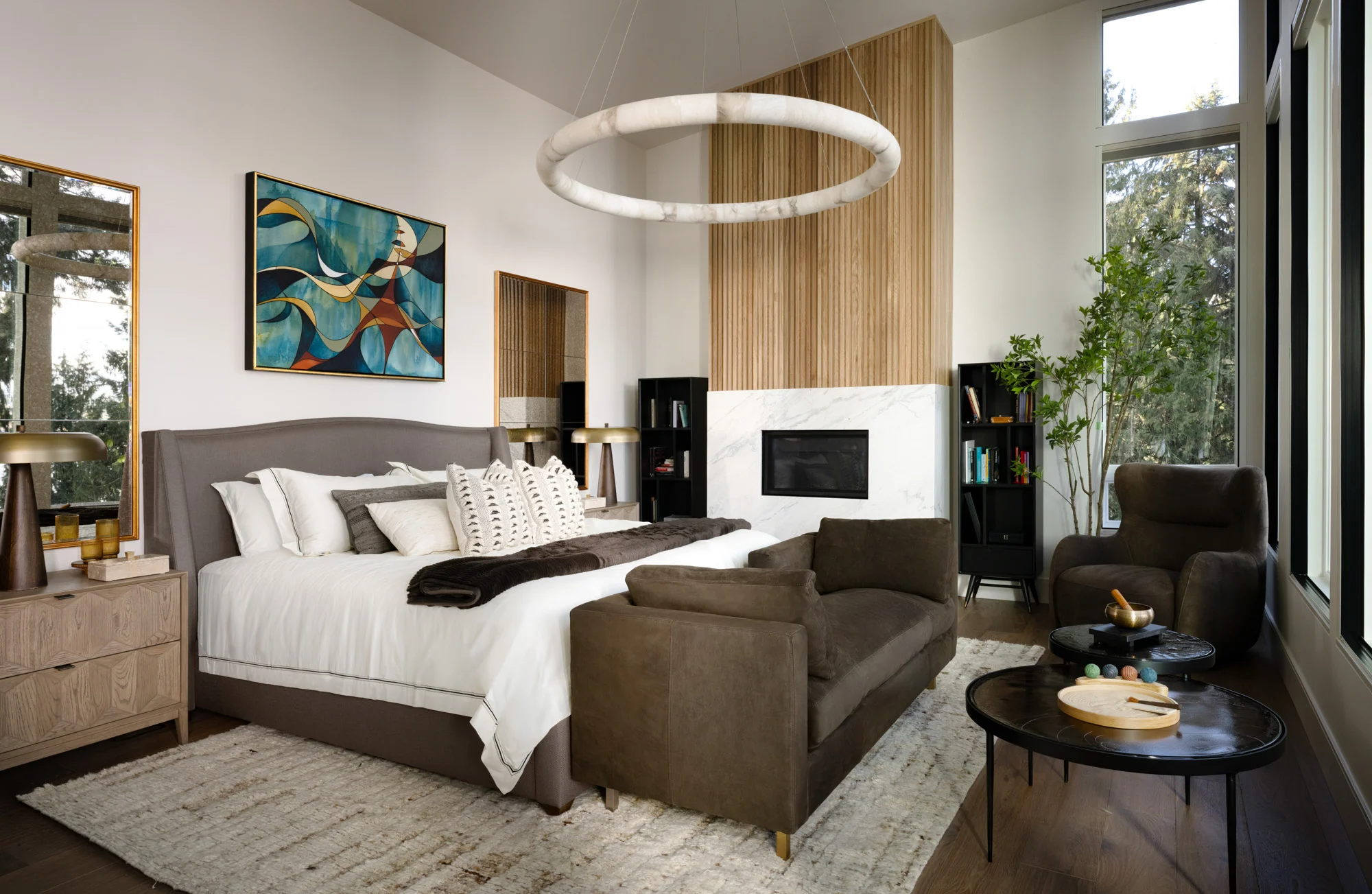 Elegant primary bedroom with modern fireplace, custom wood accents, and layered neutral furnishings designed by Artful Conceptions.