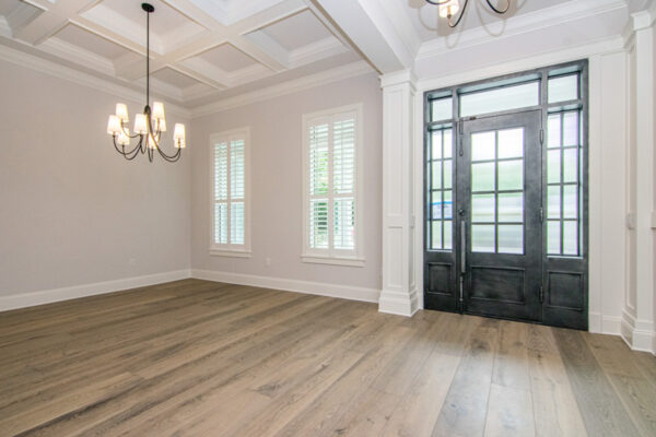 Spacious living room with a contemporary design, featuring a comfortable sofa, decorative throw pillows, and a modern coffee table. The open layout flows into the adjacent dining room, creating a seamless connection between the two spaces. Large windows bring in ample natural light, highlighting the neutral color palette and elegant decor. The dining area is furnished with a stylish table and chairs, creating a cohesive and inviting atmosphere throughout the room.